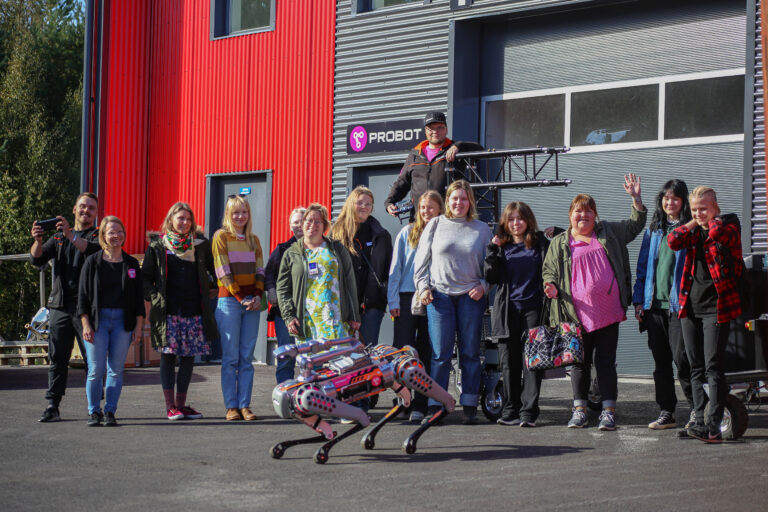 Photo of students, teachers and robot dog.
